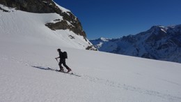 Eine Person beim Aufstieg mit den Skis zum Leiterberg.