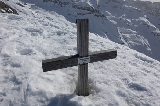 Das Gipfelkreuz vom Naebelchaeppler, umgeben von Schnee.